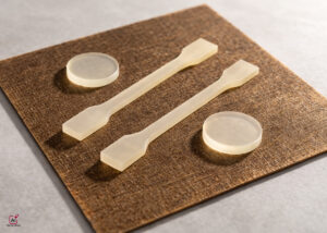 Bio-based formulated epoxy resin test bars and circular specimens placed on composite material sample for sustainable industrial composite applications