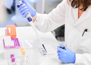 Laboratory technician pipetting liquid into a well plate in a modern research setting—illustrating Nagase’s Latex Particle technology used in precision bioassays, diagnostics, and life science applications.