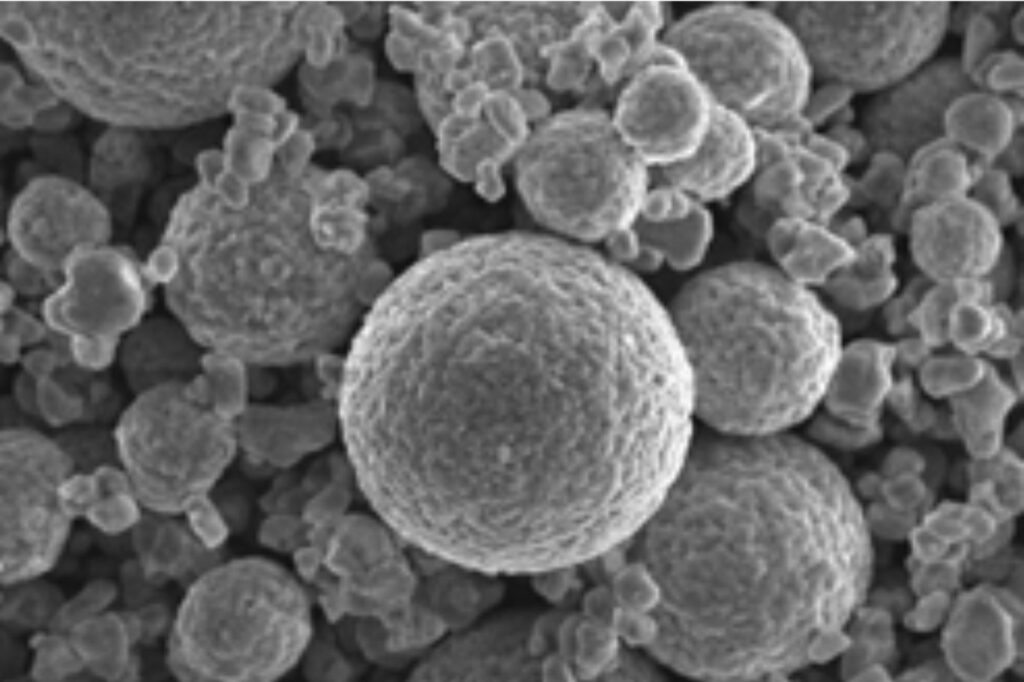 High-resolution SEM image of spherical cathode material particles by Nagase Mobility, showcasing uniform granular structure ideal for automotive battery technology, enhancing energy density and stability in electric vehicle applications.