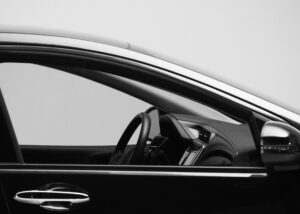 Side view of a modern car interior with steering wheel and dashboard, representing Nagase AddCoat Wire for mobility, providing advanced coating technology for durability, safety, and reliability in automotive applications.