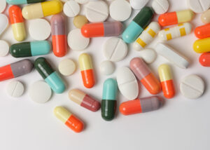 Assorted pharmaceutical tablets and capsules in various shapes and colors on a white background, showcasing the formulation versatility of SUNMALT by Nagase for advanced drug delivery and in-vitro diagnostic applications.