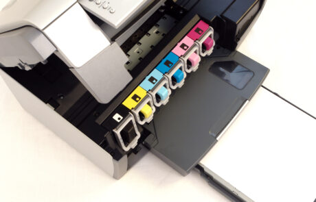 Close-up of an inkjet printer with six color cartridges (black, yellow, cyan, light cyan, magenta, light magenta) exposed—illustrating the role of Charge Control Agents in high-precision color management for advanced printing applications by Nagase.