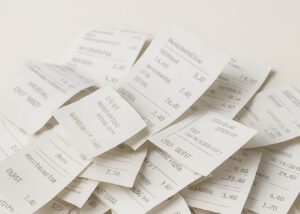 Scattered thermal paper receipts printed in crisp black ink—demonstrating the effectiveness of DPS (Diphenyl Sulfone) Sensitizer in enhancing print clarity and durability for commercial printing applications by Nagase.