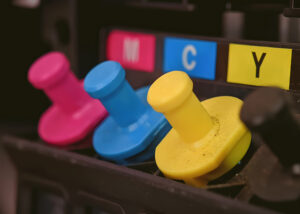 Close-up of CMYK ink cartridges in a printer, representing Nagase pigment dispersions for water-based inkjet inks that deliver vibrant colors, stability, and high-performance printing solutions.