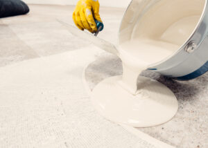Close-up of applying electrically conductive coating with a roller, showing smooth gray epoxy layer for advanced paint and coating solutions provided by Nagase.