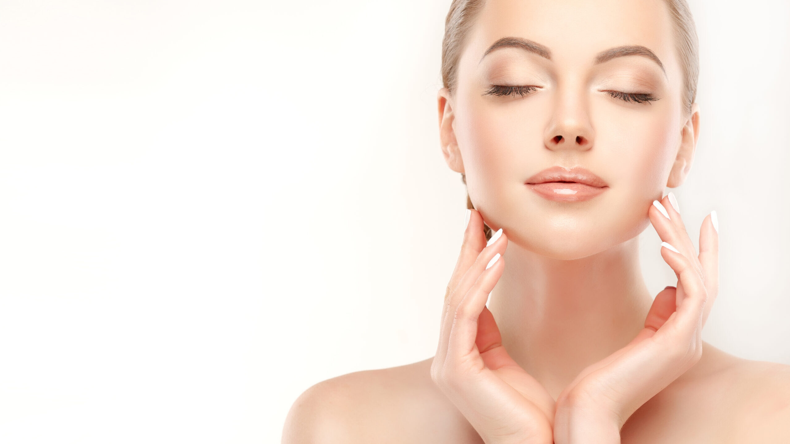 Woman with smooth, radiant skin gently touching her face, representing the mild exfoliation, impurity removal, and skin-softening benefits of BIODIOS™ Scrub biodegradable hydro-gel particles.